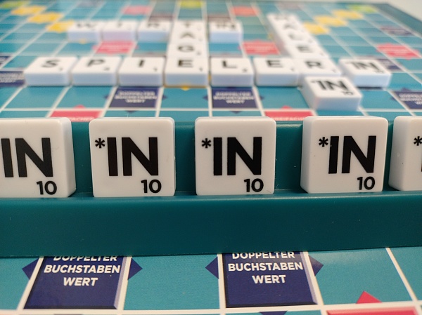 Ein Scrabble-Spielbrett mit Gender-Steinen für *in